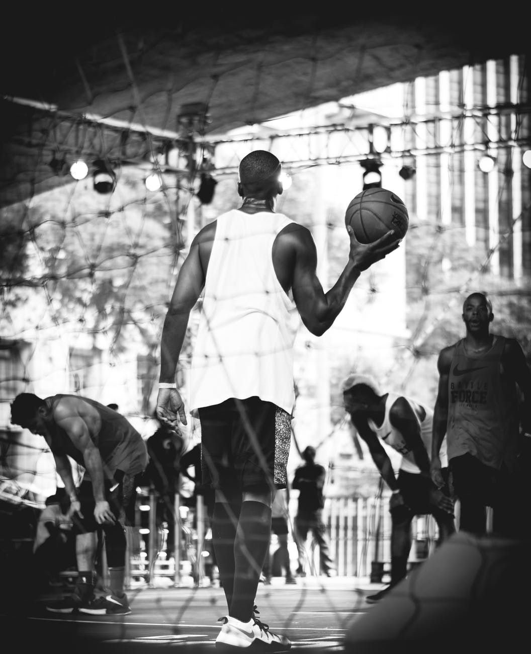 grayscale photography of man holding basketball ball